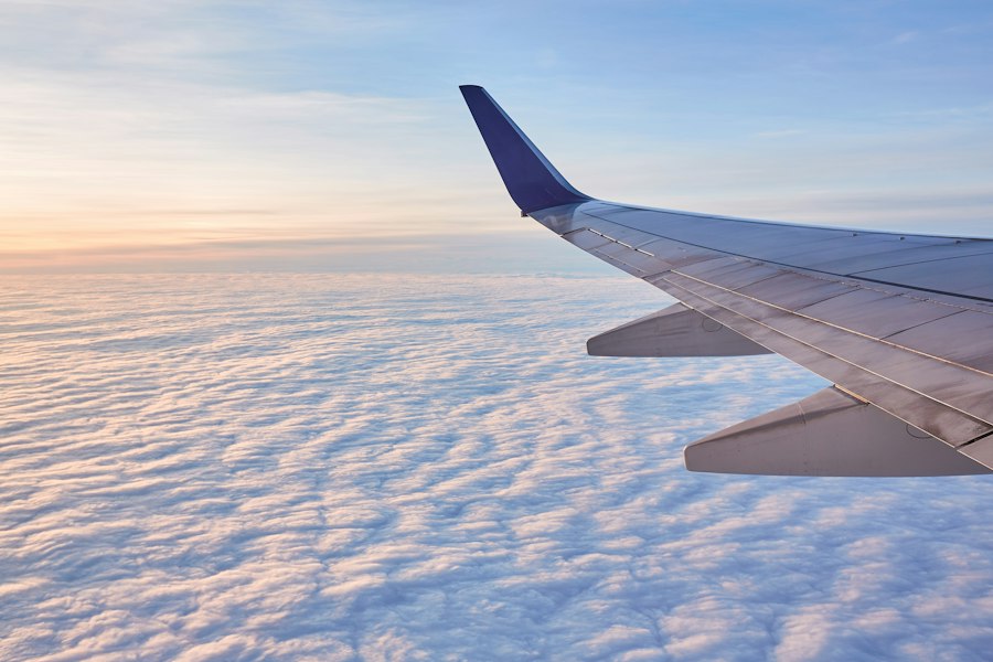 Blick aus dem Flugzeugfenster auf Tragfläche über den Wolken